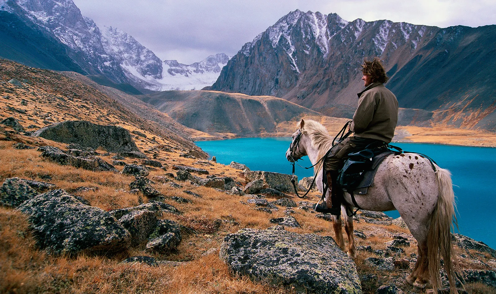 Tim Cope, the author, on his horse in a mountain valley.